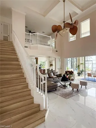 a living room with furniture kitchen view and a chandelier