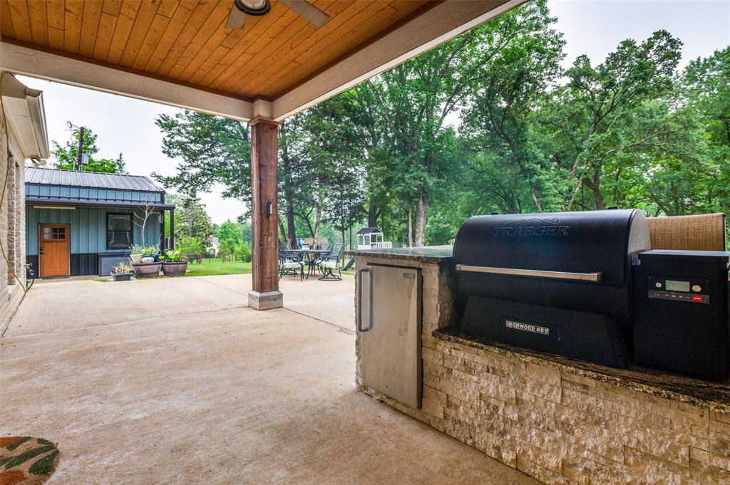 586 Rustic Oaks Road Combine, TX 75159 - Photo 30 of 39 Built in Grill, outdoor kitchen with statement setting wood ceiling