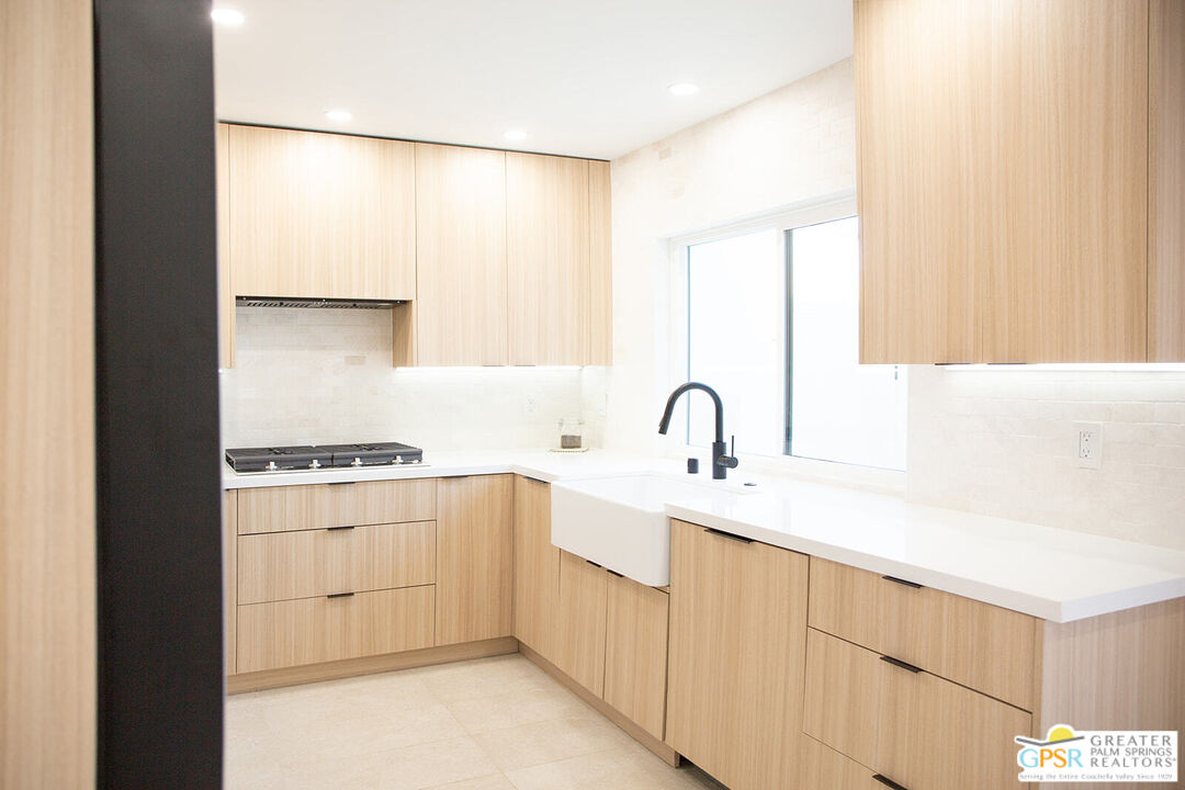 48940 Desert Flower Drive Palm Desert, CA 92260 - Photo 1 of 31 a kitchen with a sink a stove and white cabinets