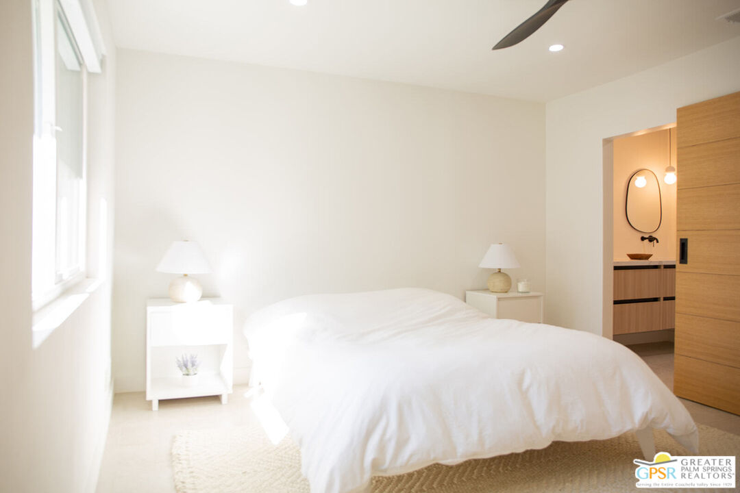 48940 Desert Flower Drive Palm Desert, CA 92260 - Photo 19 of 31 a bedroom with a bed and a mirror