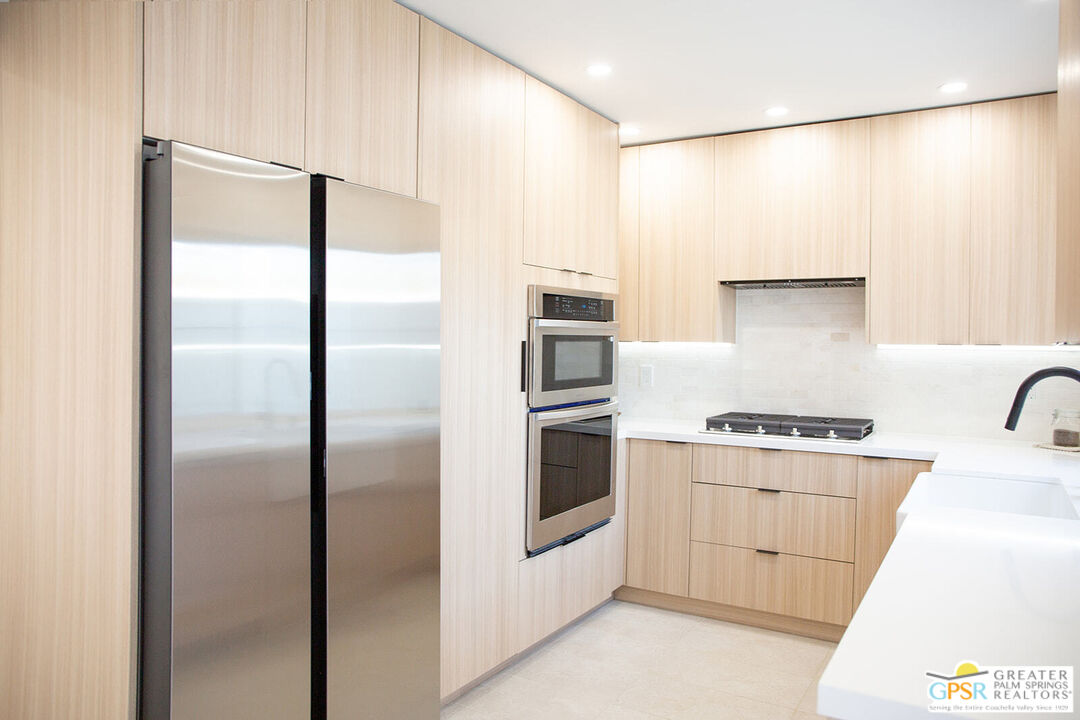 48940 Desert Flower Drive Palm Desert, CA 92260 - Photo 2 of 31 a kitchen with stainless steel appliances a refrigerator and a stove