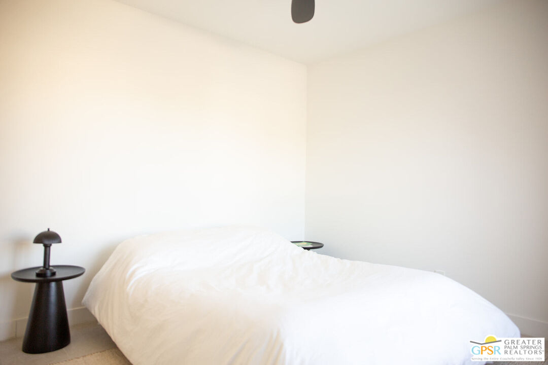 48940 Desert Flower Drive Palm Desert, CA 92260 - Photo 24 of 31 a bedroom with a white bed and a lamp