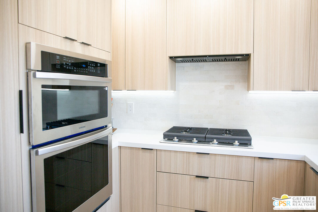 48940 Desert Flower Drive Palm Desert, CA 92260 - Photo 3 of 31 a kitchen with a stove and a microwave
