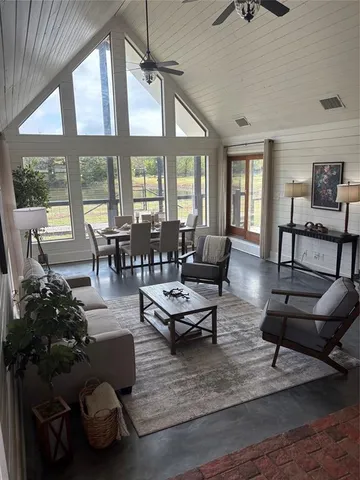 a living room with furniture fireplace and large windows