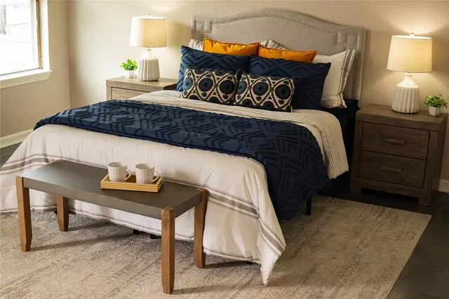 a bedroom with a bed and a lamp on dresser