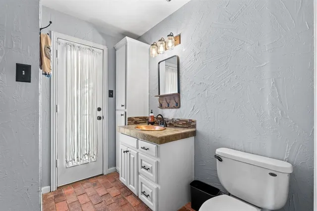 a bathroom with a toilet sink and mirror