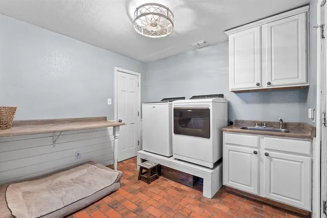 a utility room with cabinets washer and dryer