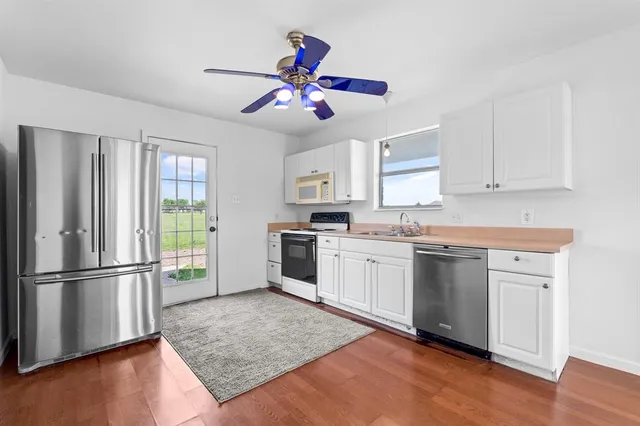 a kitchen with granite countertop stainless steel appliances a stove top oven and a refrigerator