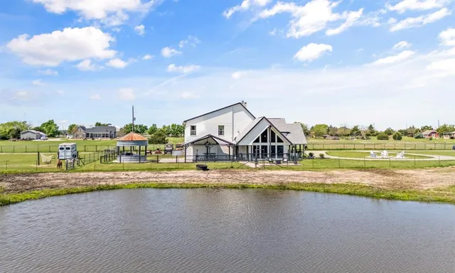 a view of a house with a big yard and large trees