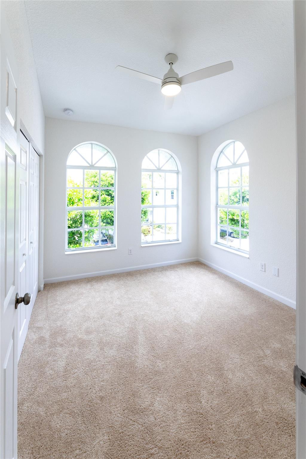 3199 Laurel Ridge Circle, Unit 3199 Riviera Beach, FL 33404 - Photo 14 of 44 an empty room with windows and an entrance door