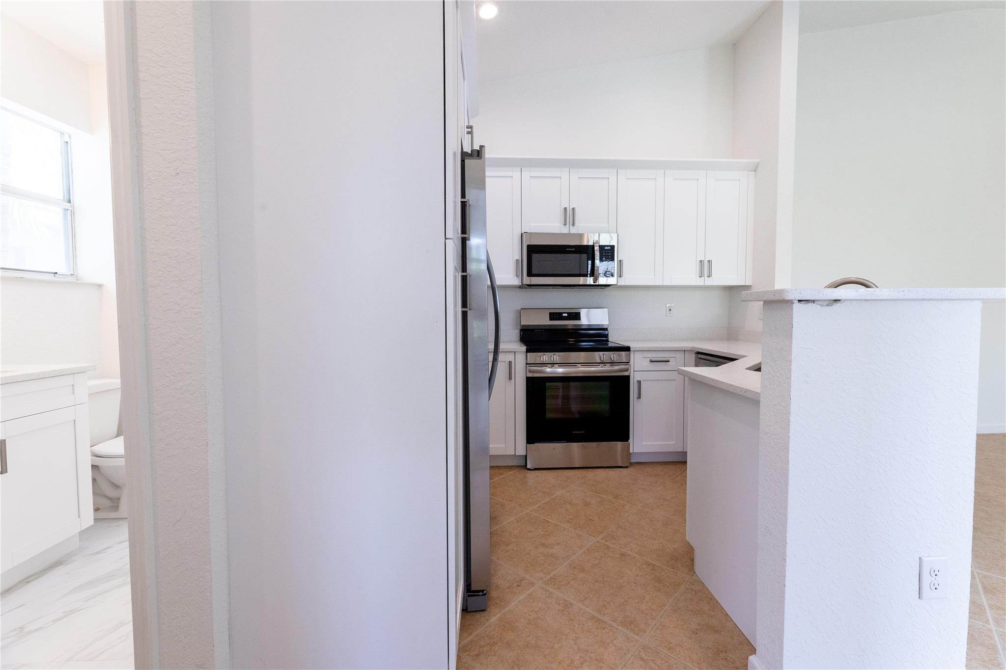 3199 Laurel Ridge Circle, Unit 3199 Riviera Beach, FL 33404 - Photo 19 of 44 a kitchen with stainless steel appliances a refrigerator and a stove