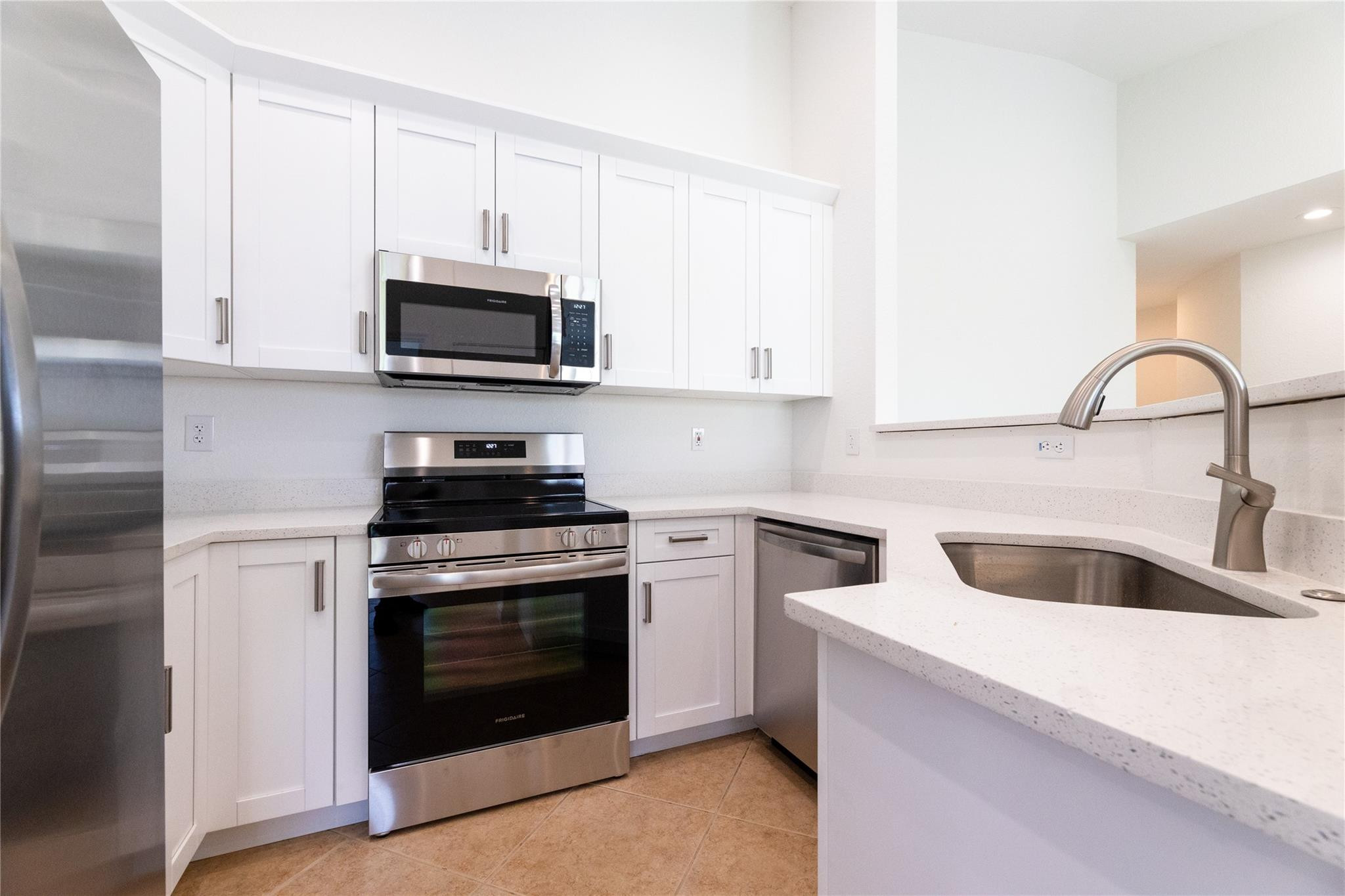 3199 Laurel Ridge Circle, Unit 3199 Riviera Beach, FL 33404 - Photo 20 of 44 a kitchen with stainless steel appliances granite countertop a sink stove and microwave