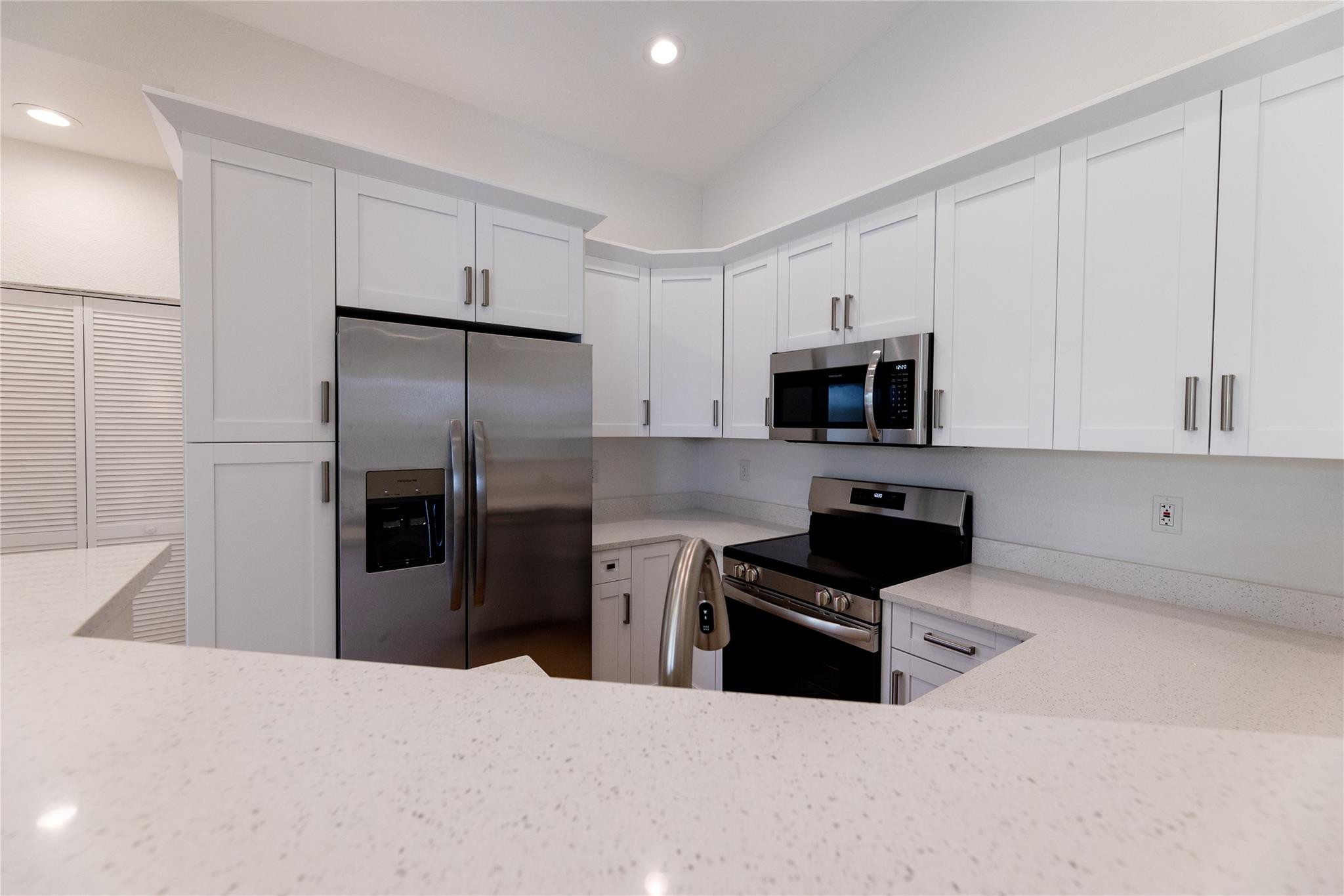 3199 Laurel Ridge Circle, Unit 3199 Riviera Beach, FL 33404 - Photo 21 of 44 a kitchen with granite countertop a refrigerator and a stove top oven
