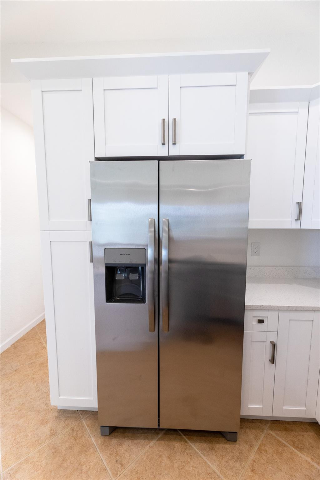 3199 Laurel Ridge Circle, Unit 3199 Riviera Beach, FL 33404 - Photo 23 of 44 a kitchen with a refrigerator and white cabinets