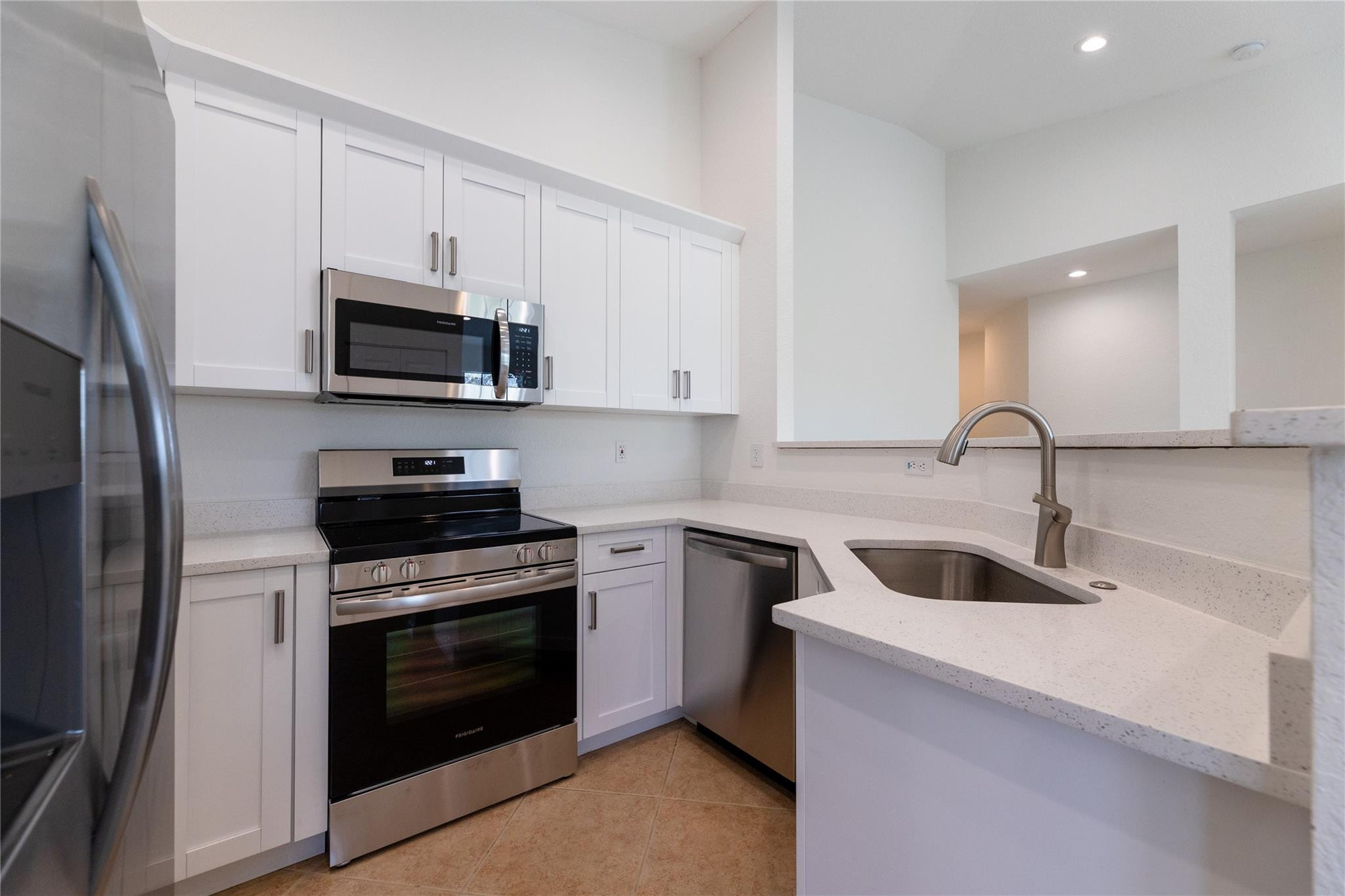 3199 Laurel Ridge Circle, Unit 3199 Riviera Beach, FL 33404 - Photo 3 of 44 a kitchen with white cabinets and stainless steel appliances
