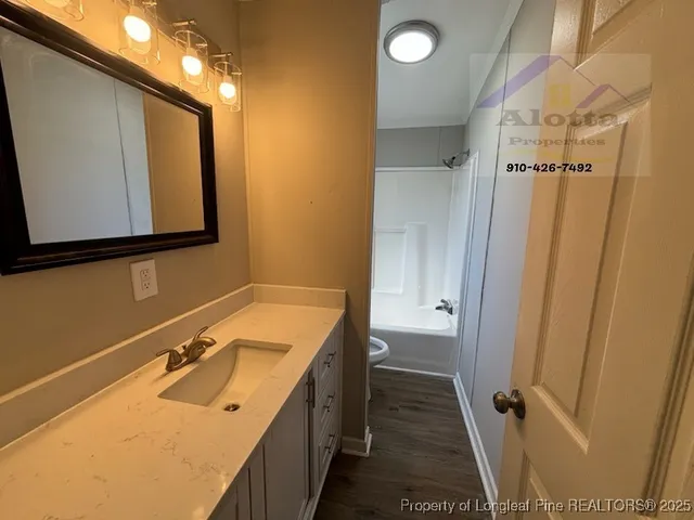 a bathroom with a sink and mirror with bathtub