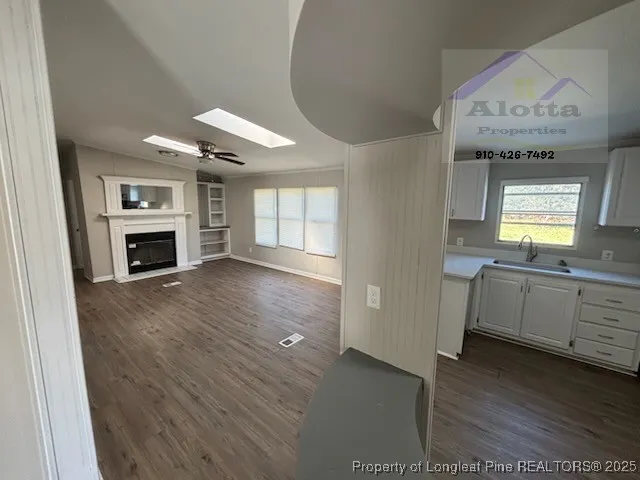a view of an empty room with a fireplace and a window