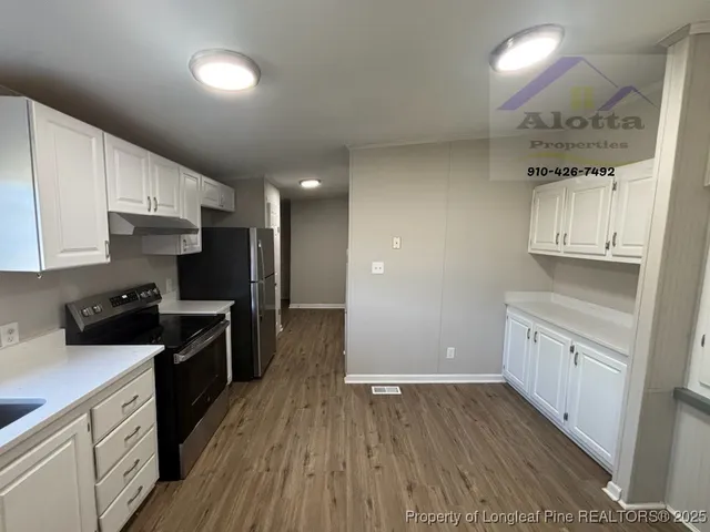 a kitchen with cabinets wooden floor and stainless steel appliances