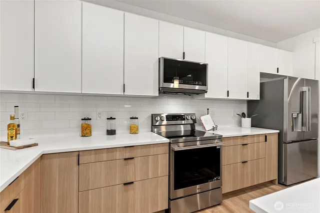 a kitchen with cabinets stainless steel appliances and a sink