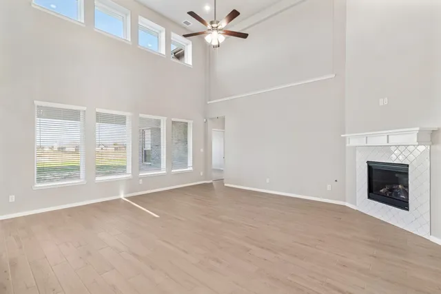 an empty room with windows and fan