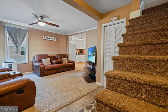 a living room with furniture and a ceiling fan