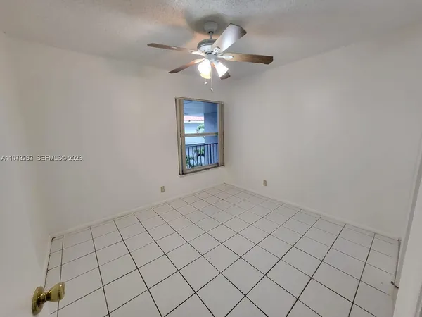an empty room with windows and fan