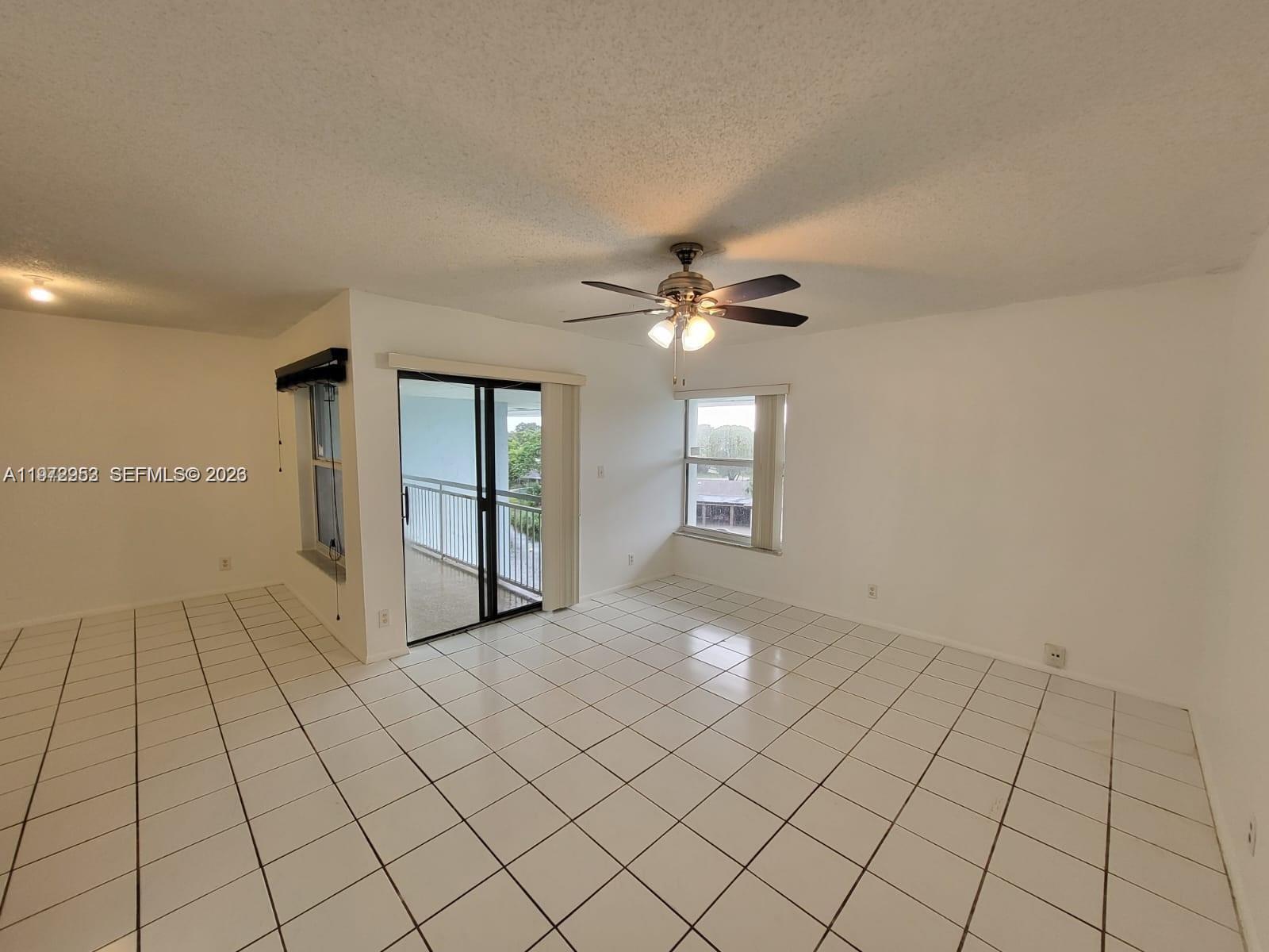 455 South Pine Island Road, Unit 410C Plantation, FL 33324 - Photo 9 of 35 a view of an empty room with window and chandelier fan