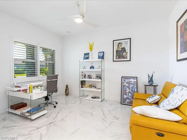 a bedroom with furniture and a large window