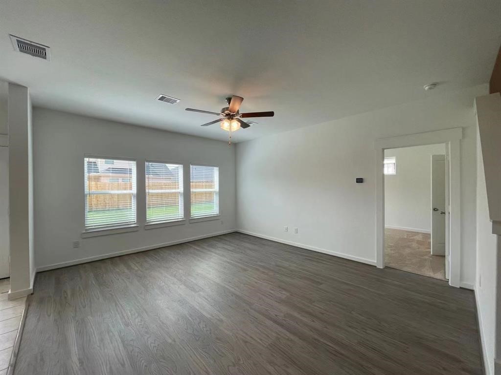 815 Summer Village Way Rosenberg, TX 77469 - Photo 7 of 21 an empty room with wooden floor fan and windows