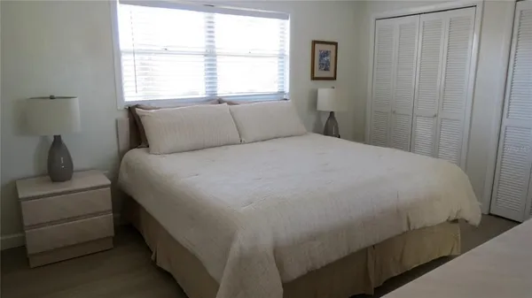 a large bed sitting in a bedroom next to a window