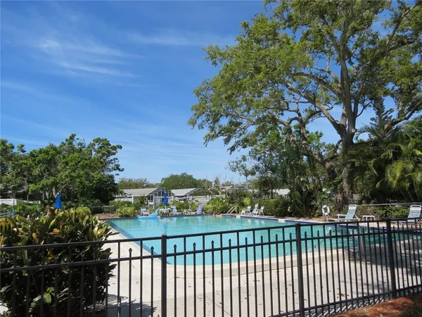 a view of a swimming pool with a patio and a yard