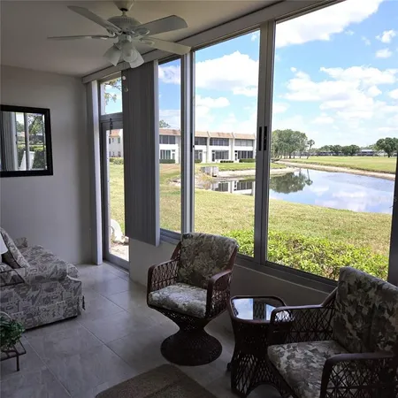 a living room with furniture and floor to ceiling windows