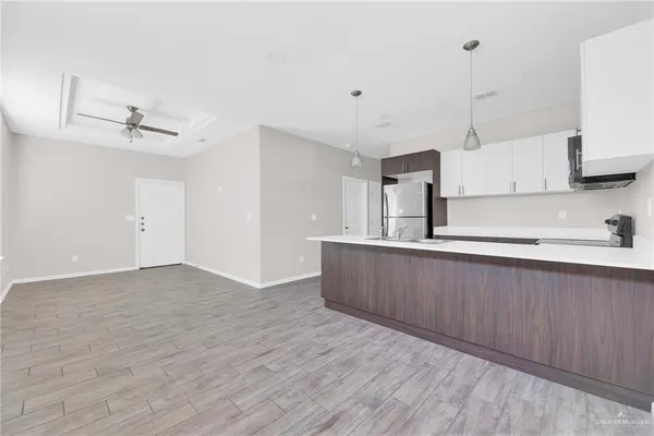 a kitchen with stainless steel appliances granite countertop a sink a stove and a wooden floors