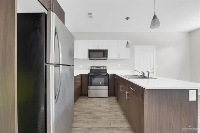 a kitchen with stainless steel appliances granite countertop a refrigerator and a stove