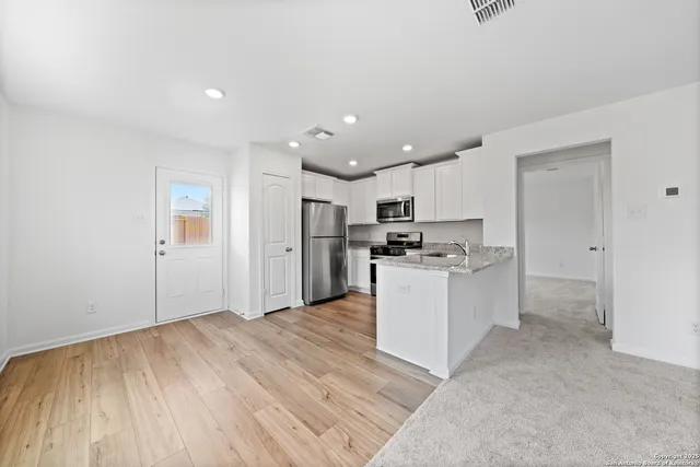 a kitchen with a refrigerator and a stove top oven