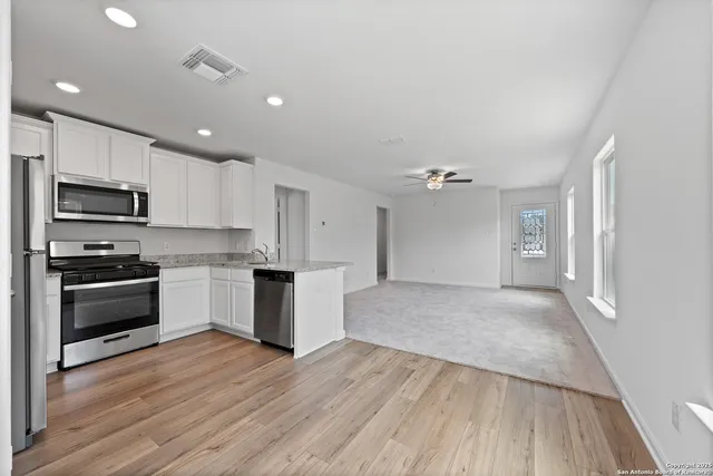 a kitchen with granite countertop a stove top oven and cabinets