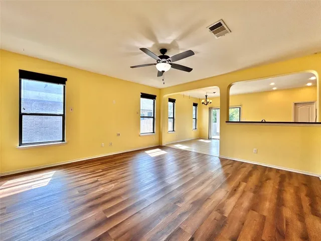 a view of a kitchen with wooden floor and a ceiling fan