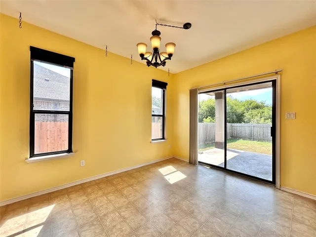 a view of an empty room with wooden floor and a ceiling fan