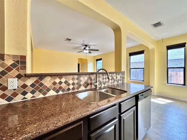 a kitchen with stainless steel appliances granite countertop a sink and a refrigerator