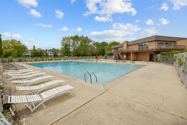 a view of a sign board of a house with a yard and wooden fence