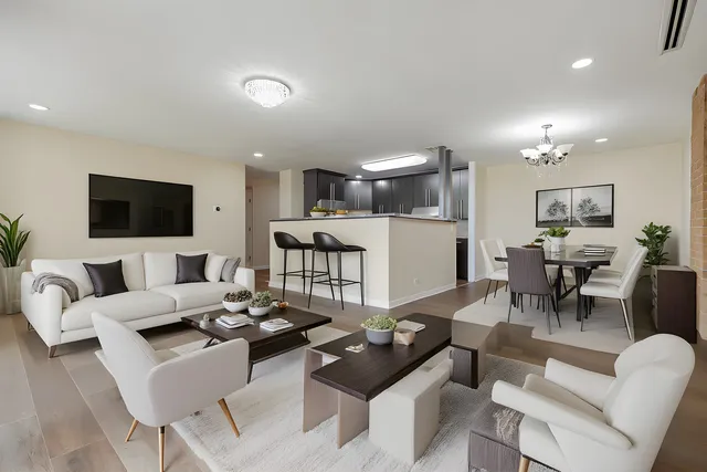 a living room with furniture a flat screen tv and kitchen view