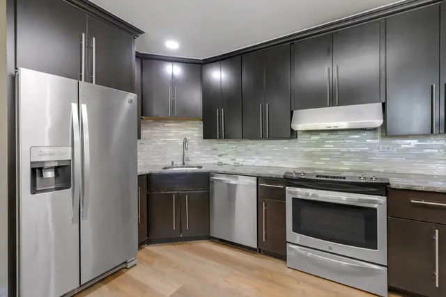 a kitchen with granite countertop stainless steel appliances and refrigerator