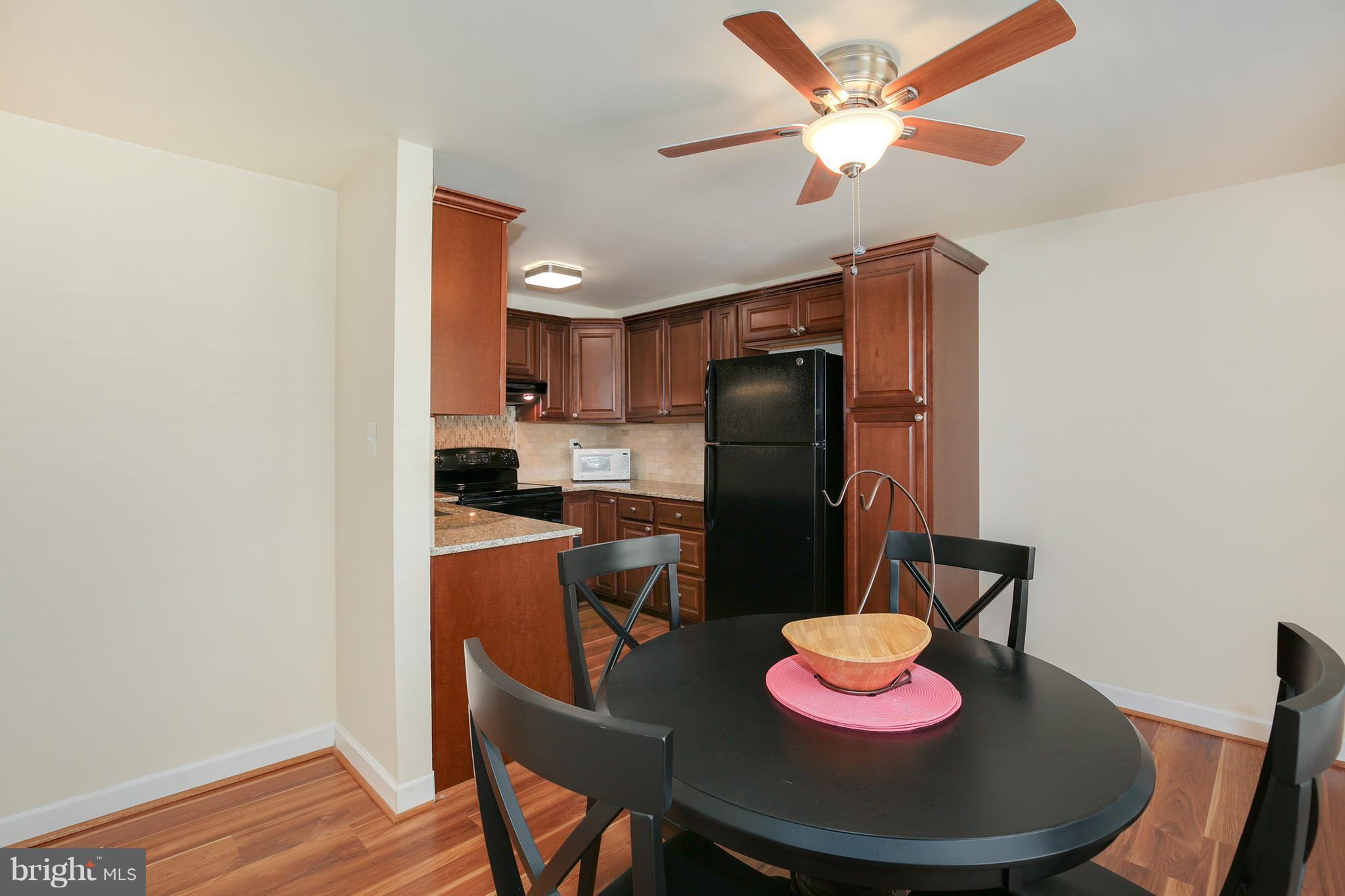 17555 Kohlhoss Road Poolesville, MD 20837 - Photo 11 of 24 a kitchen with stainless steel appliances granite countertop a sink dishwasher and a refrigerator with wooden floor