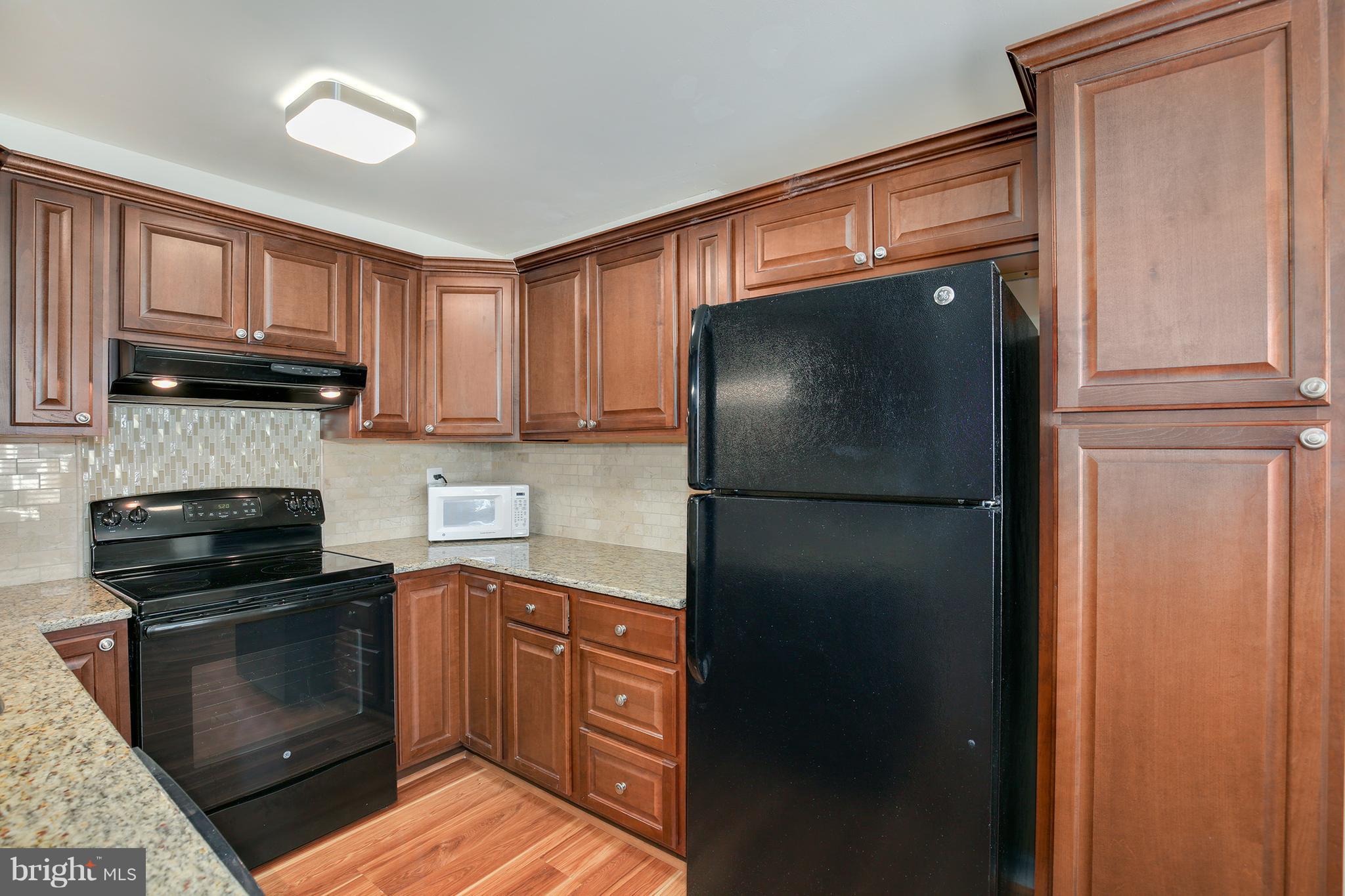 17555 Kohlhoss Road Poolesville, MD 20837 - Photo 12 of 24 a kitchen with stainless steel appliances granite countertop a refrigerator and a stove top oven