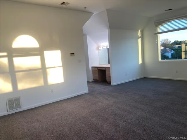 an empty room with a fireplace and windows
