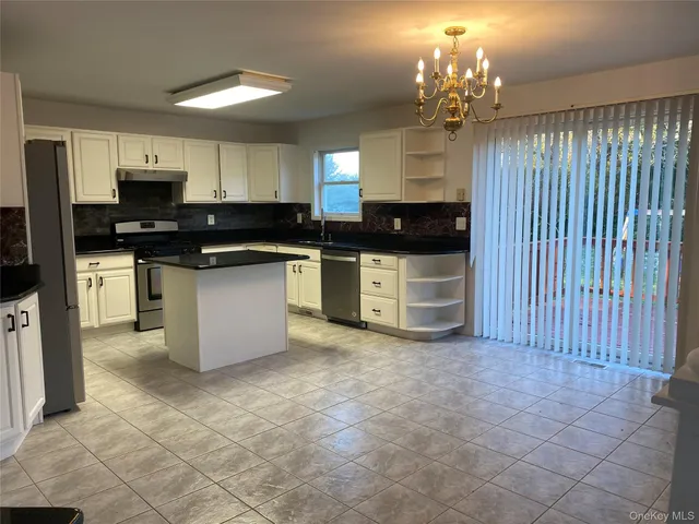a view of an empty room with a windows and fireplace