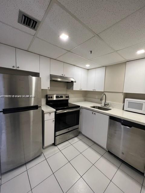 Mid Beach Miami Beach, FL 33140 - Photo 6 of 12 a kitchen with granite countertop a refrigerator and a sink