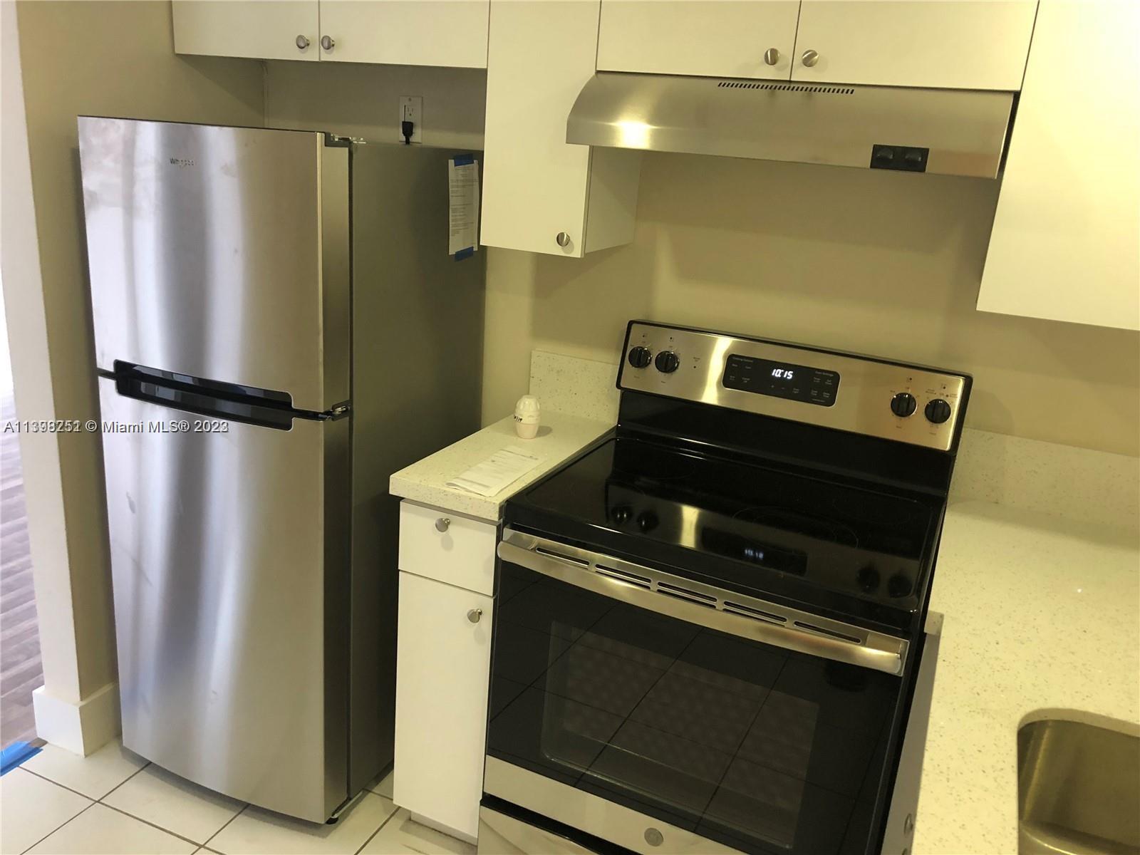 Mid Beach Miami Beach, FL 33140 - Photo 7 of 12 a metallic refrigerator freezer sitting in a kitchen