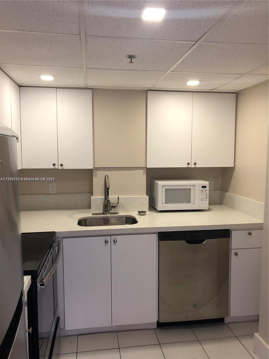 Mid Beach Miami Beach, FL 33140 - Photo 8 of 12 a kitchen with a sink and cabinets