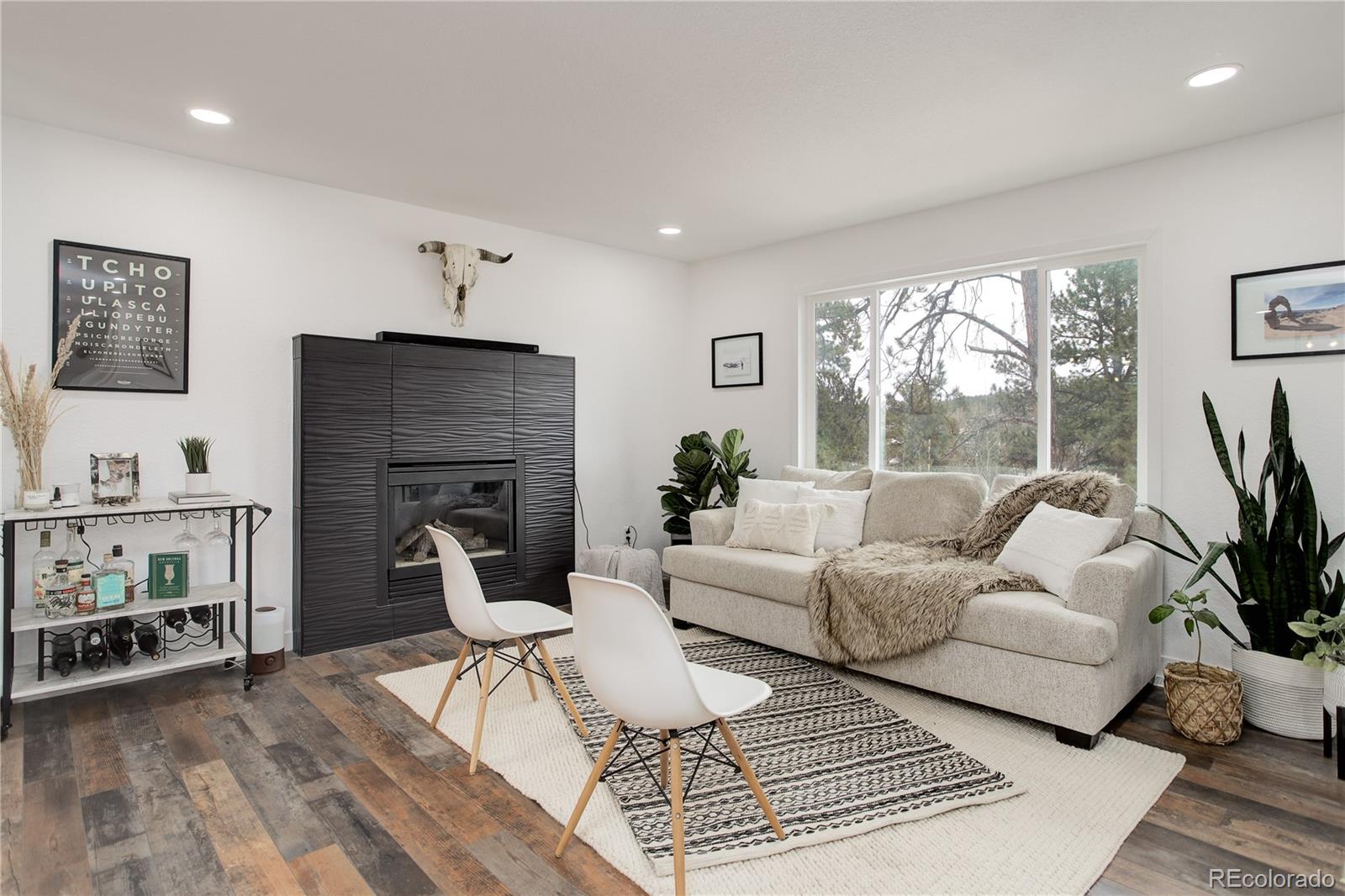95 Fitzsimmons Road Bailey, CO 80421 - Photo 11 of 38 a living room with furniture and a fireplace